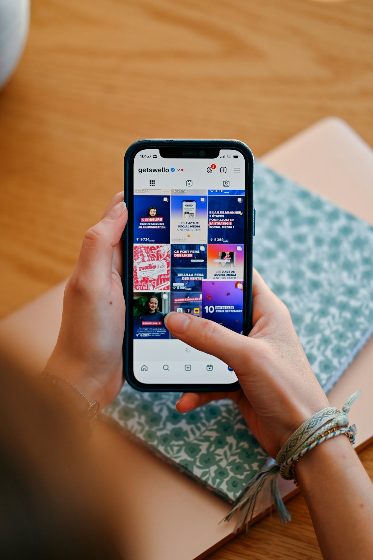 Hands holding a phone showing a social media feed managed for a brand
