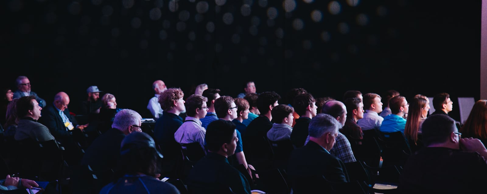 Audience seated in an auditorium during a conference with live interpreting