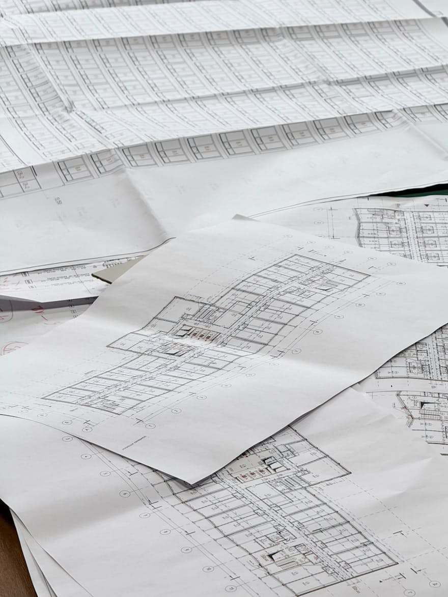 Technical patent drawings spread across a review desk