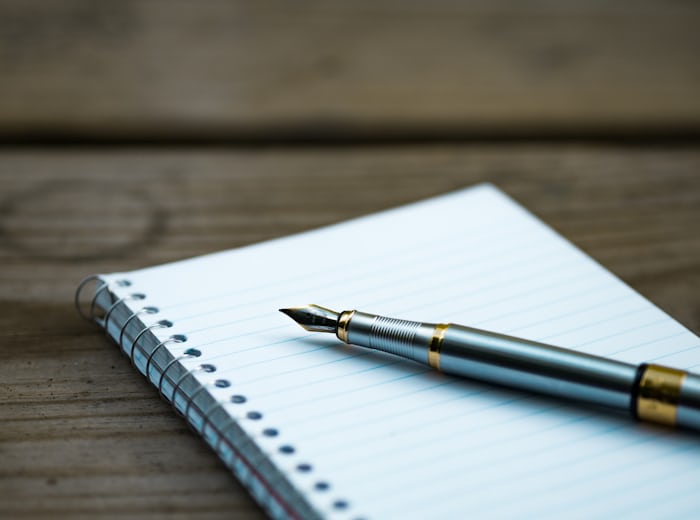 Pen and notebook representing the craft of translation and transcription